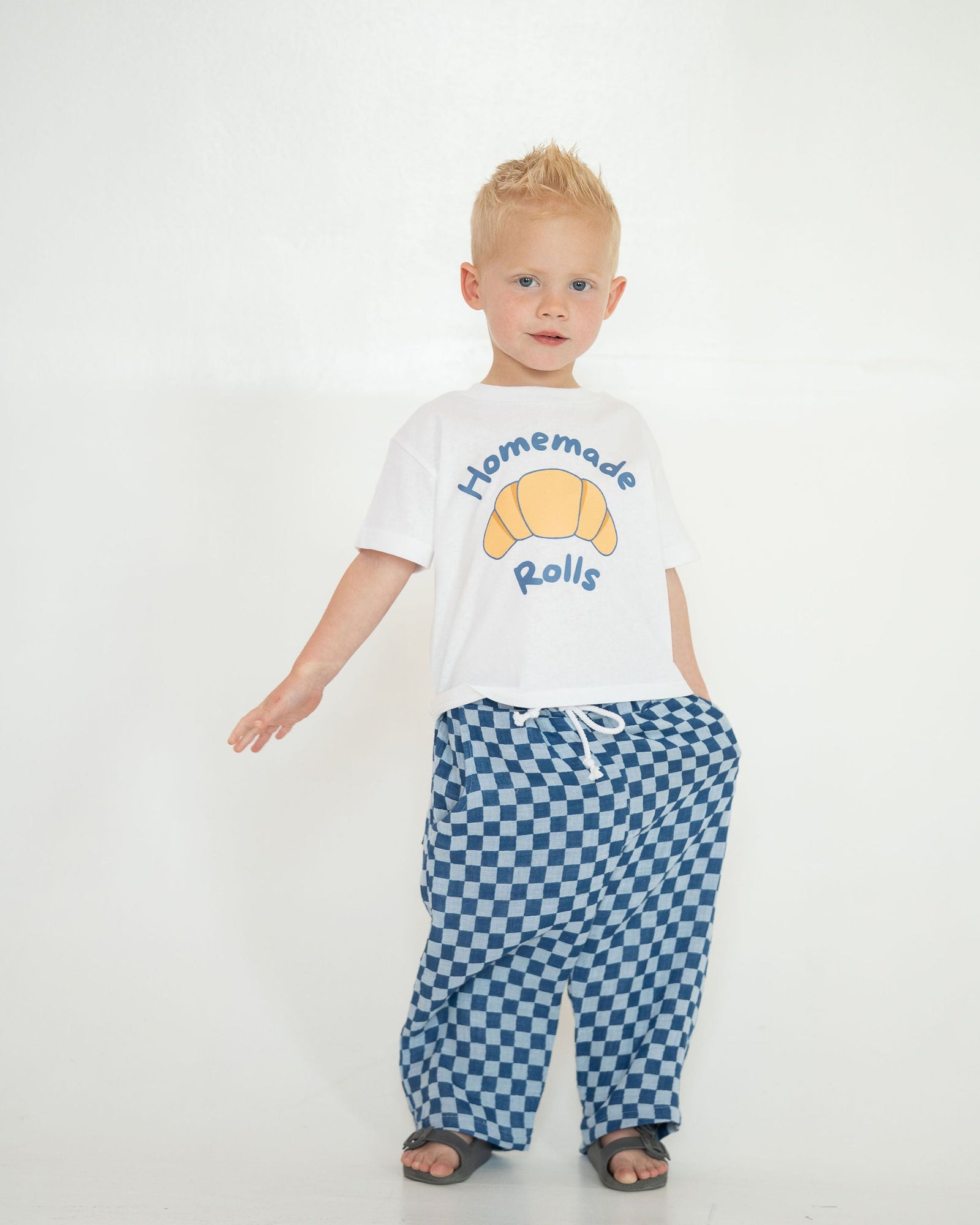 White t-shirt with a croissant graphic and 'Homemade Rolls' text on a white background