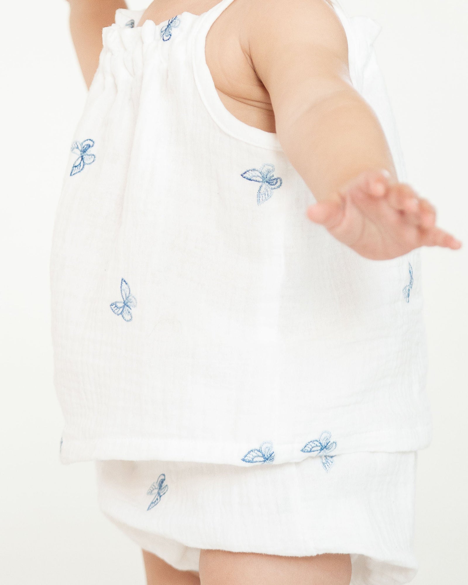 White baby bloomers with blue butterfly patterns on a white background