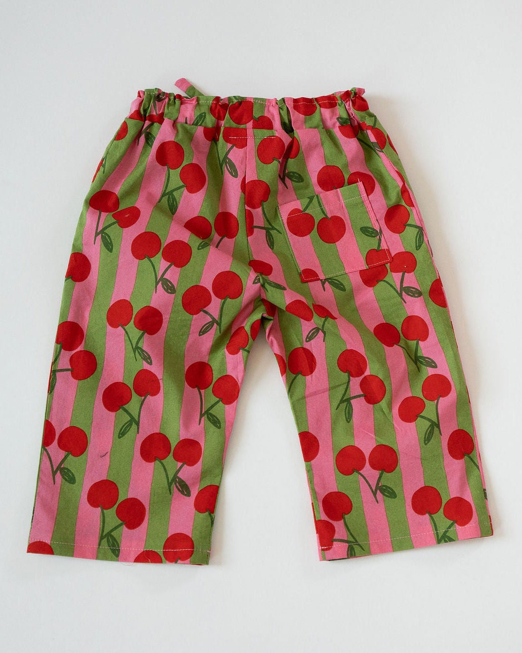 Children's pants with cherry pattern on a white background