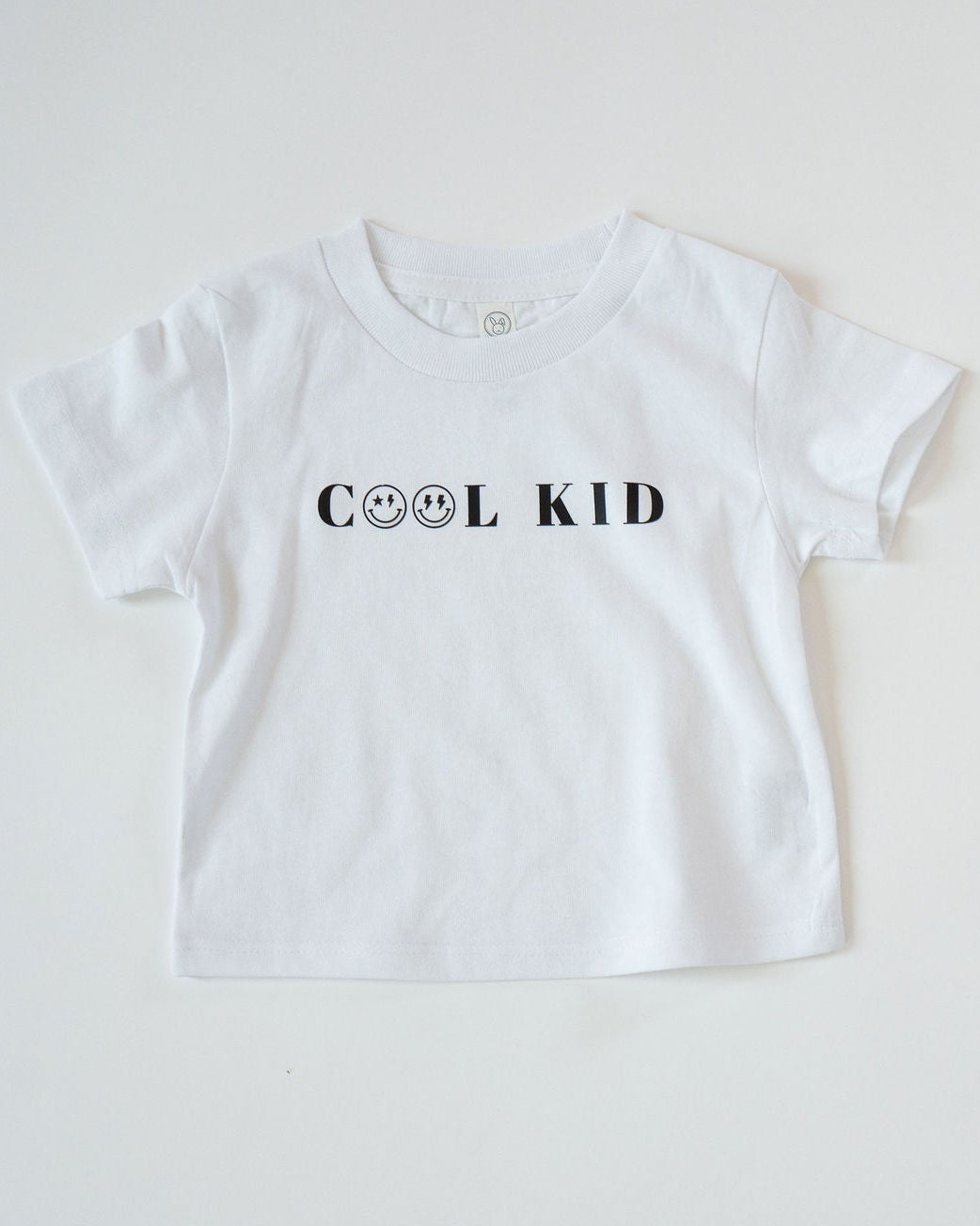 White t-shirt with 'COOL KID' text on a light gray background