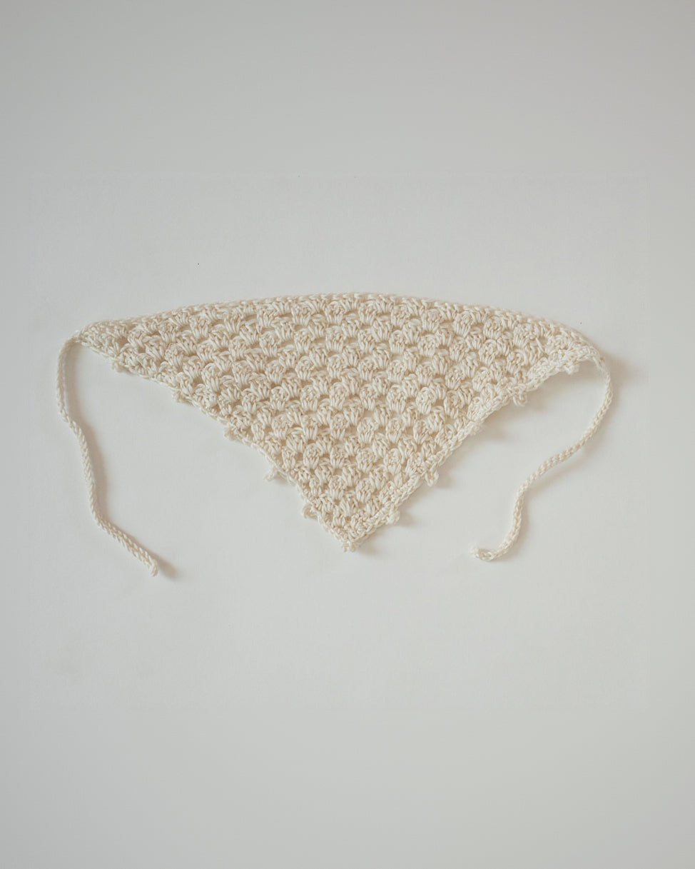 Knitted beige headband on a light gray background