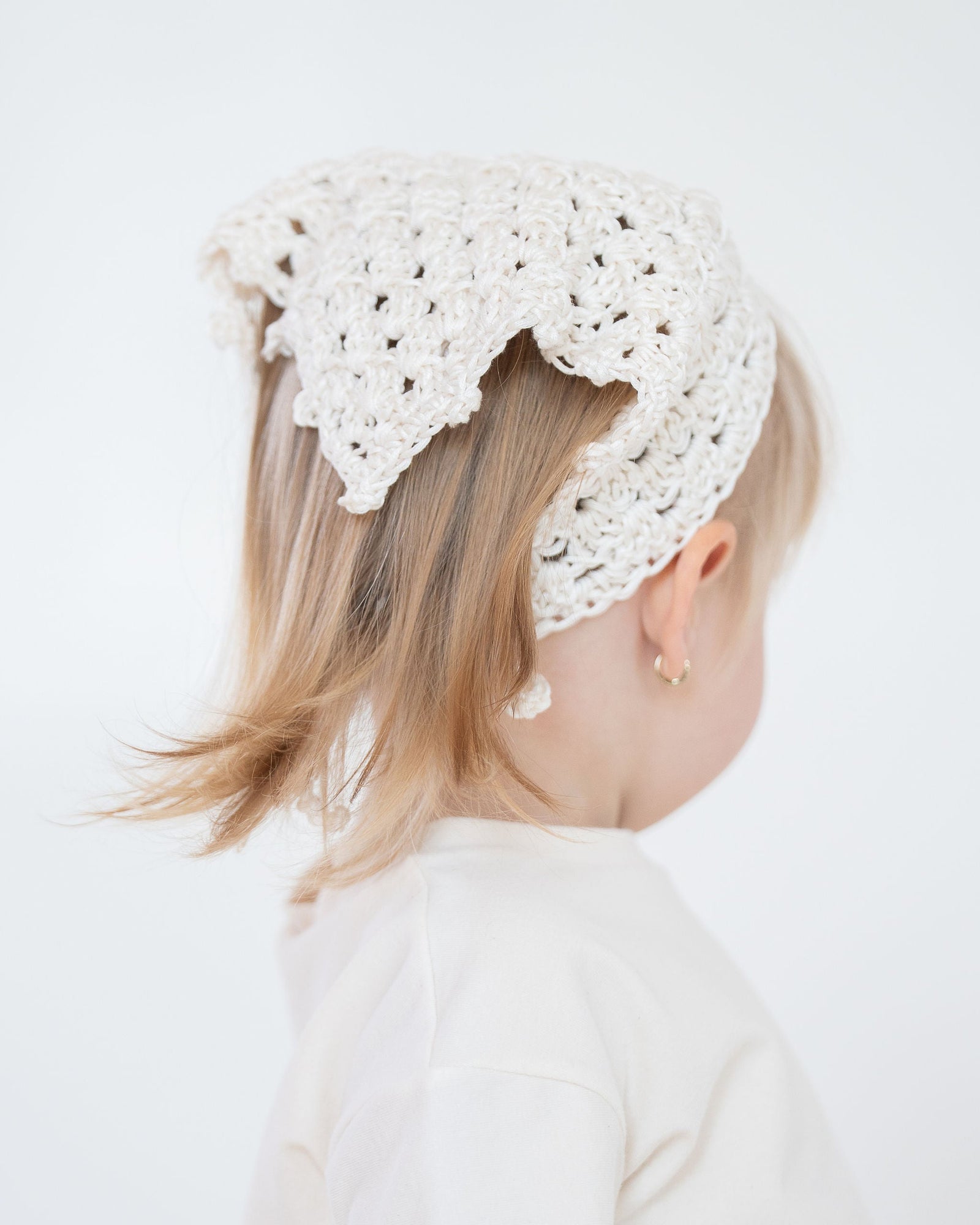 Knitted beige headband on a light gray background