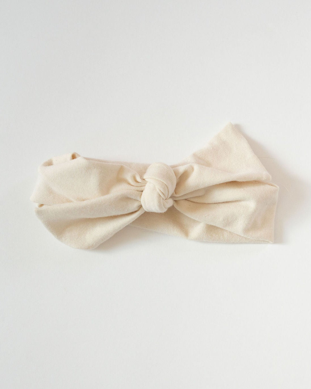 Beige bow headband on a light gray background