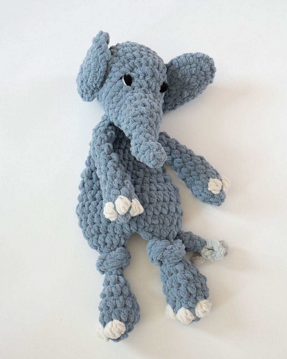 Crocheted blue elephant toy on a white background