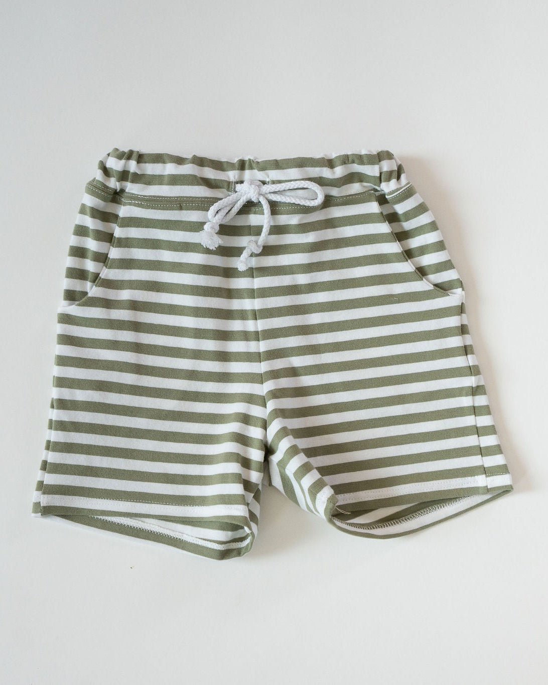 Green and white striped shorts on a light gray background