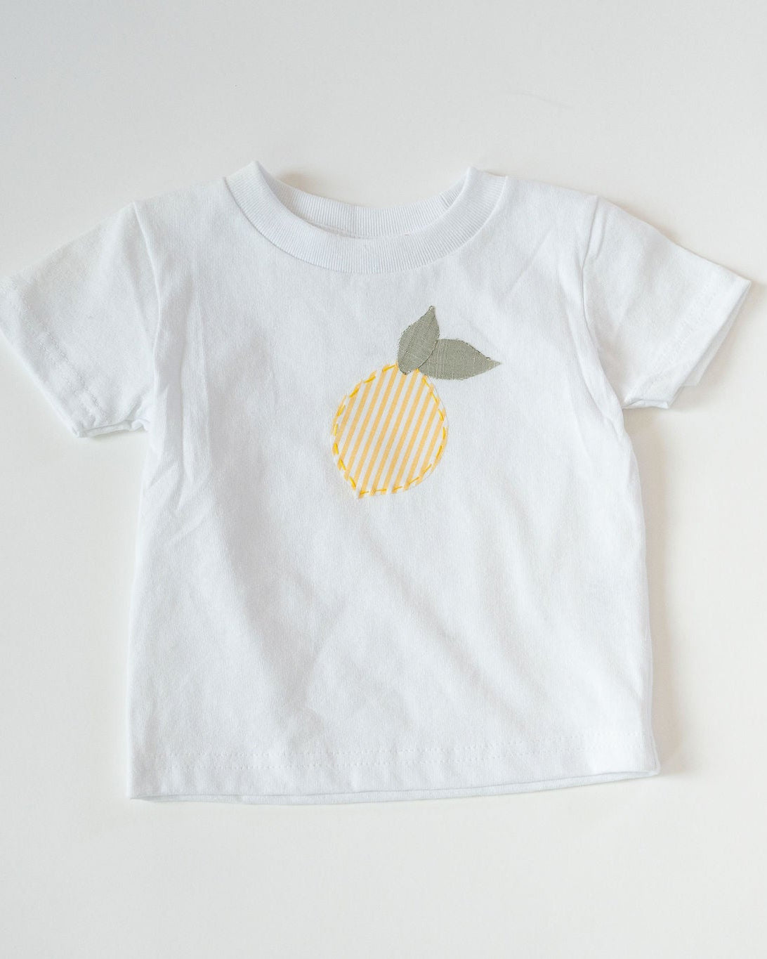 White t-shirt with a lemon design on a white background