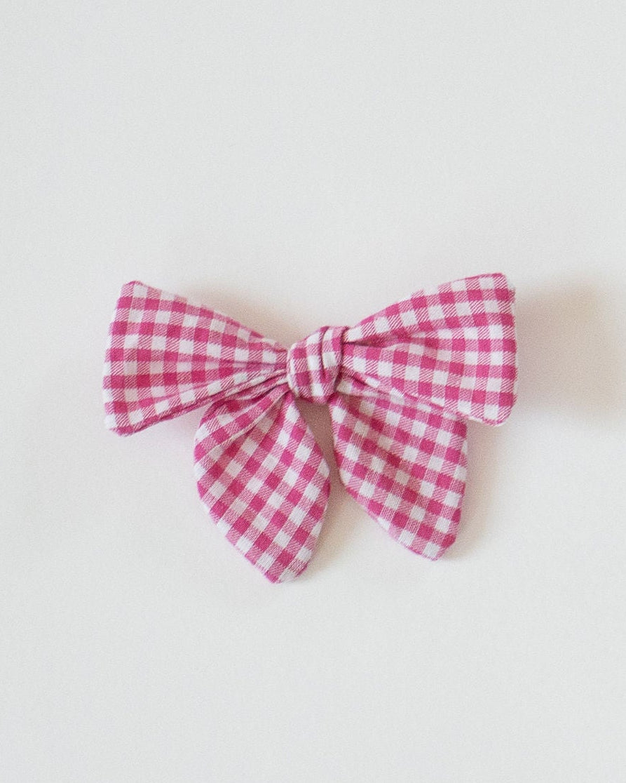 Red and white checkered bow on a light gray background