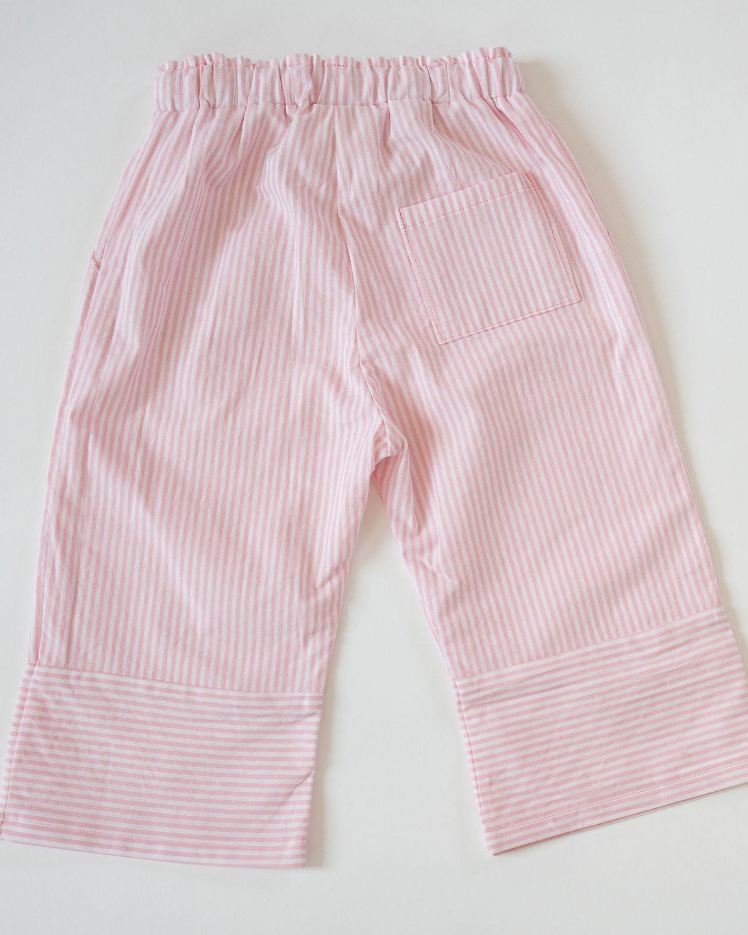 Pink striped baby pants on a white background