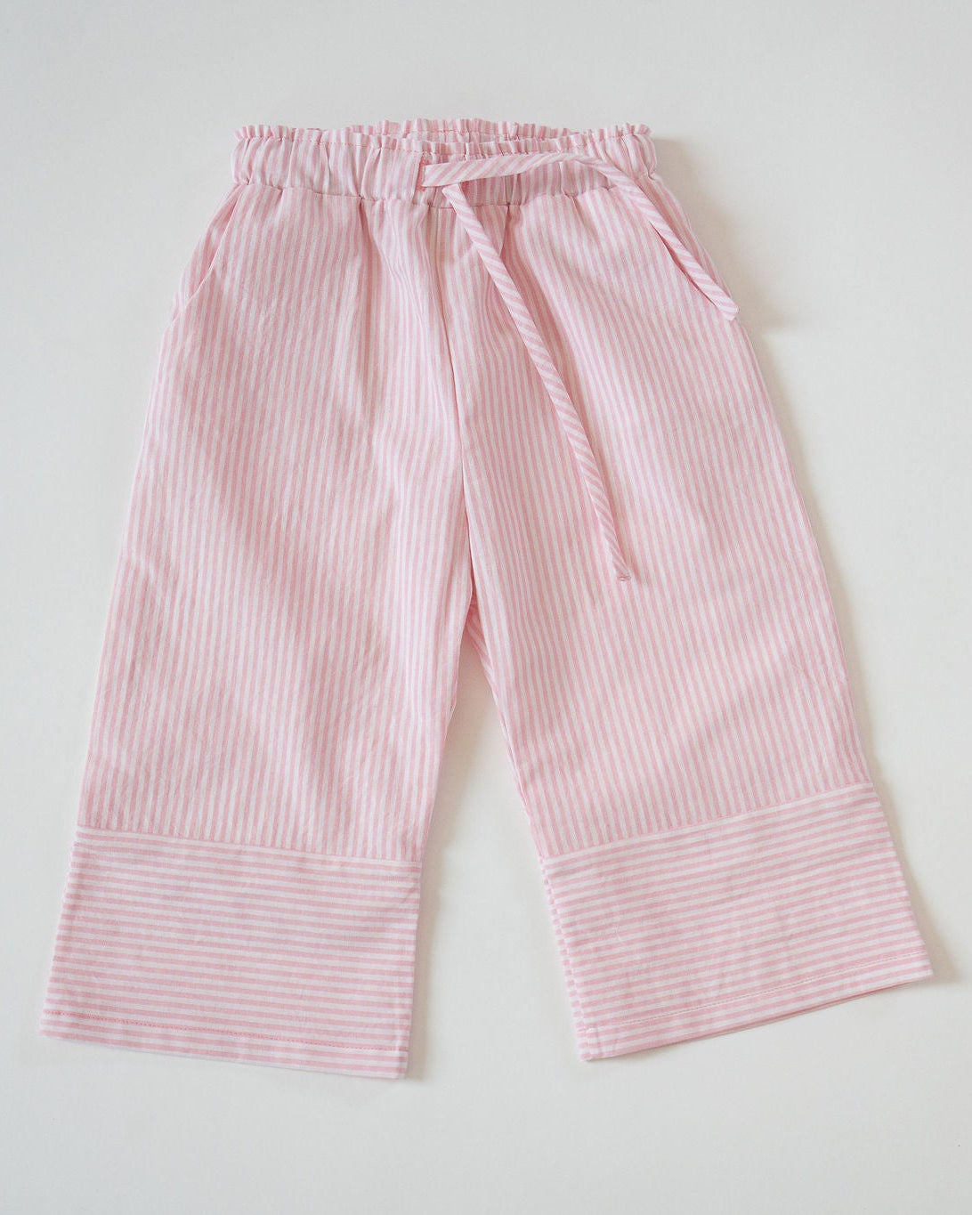 Pink striped pants on a light gray background