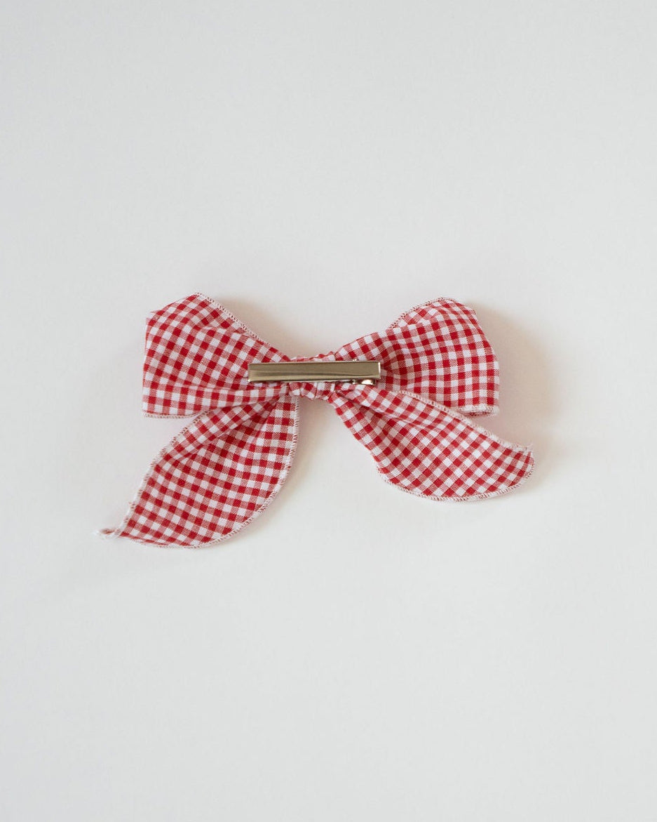 Red and white checkered bow on a light gray background