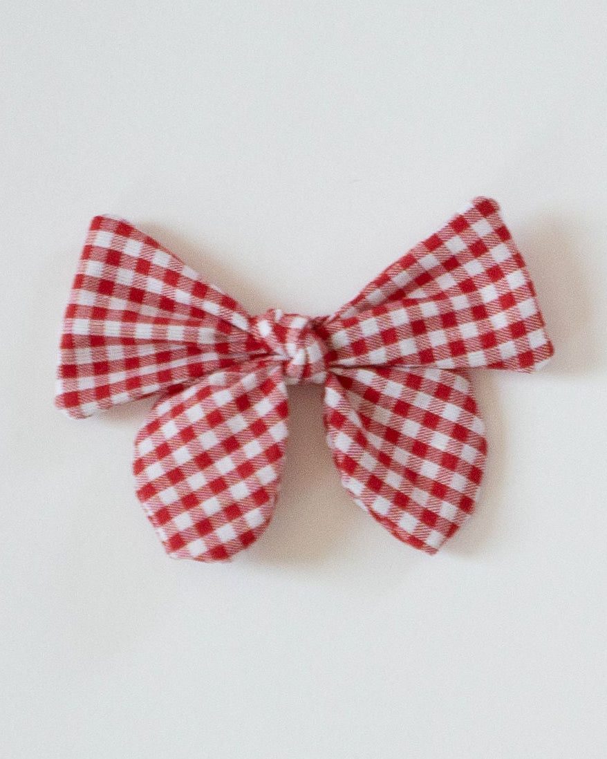 Red and white checkered bow on a light gray background