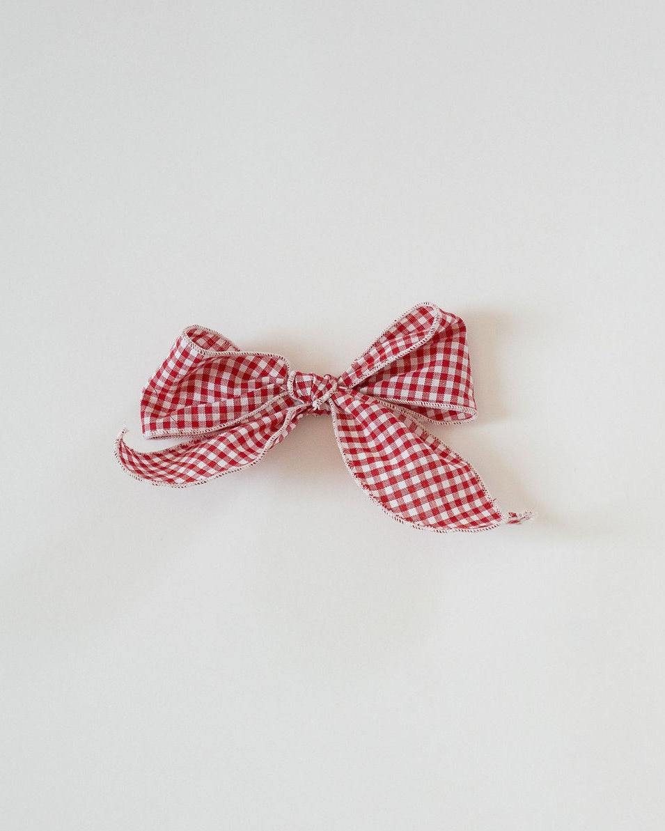Red and white checkered bow on a light gray background