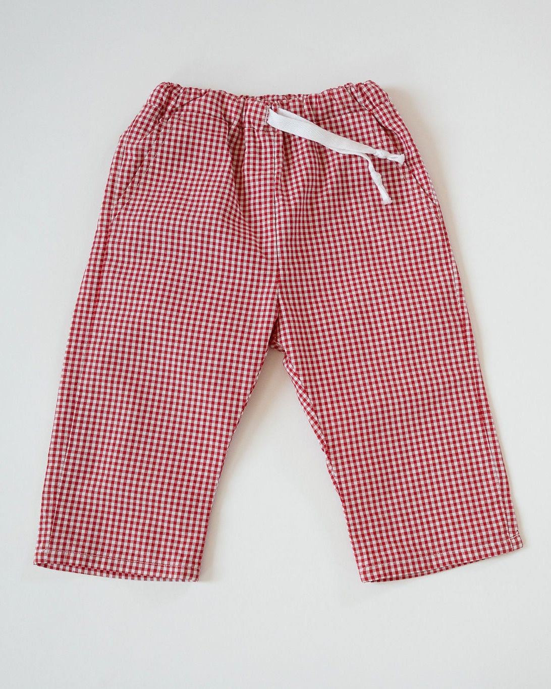 Red and white checkered pants with a drawstring on a light gray background
