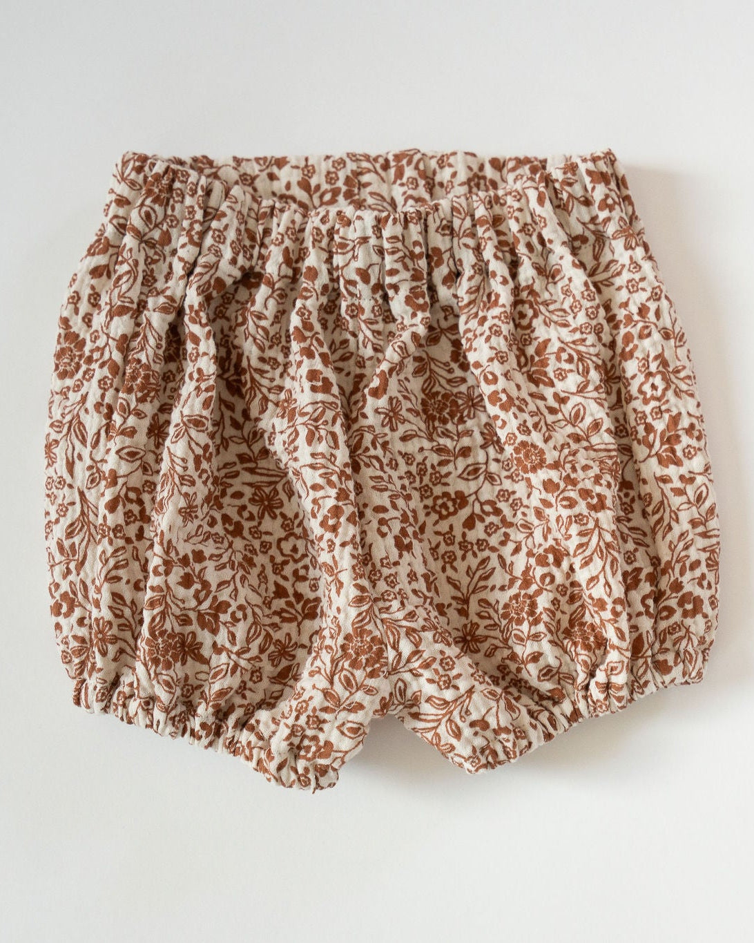 Floral patterned baby bloomers on a light gray background