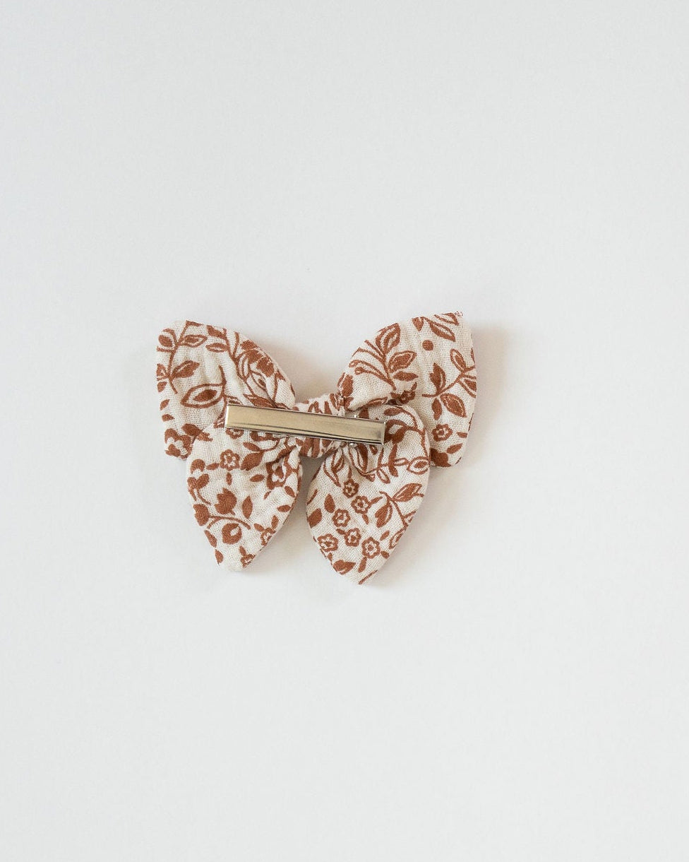 Butterfly-shaped hair clip with floral pattern on a white background
