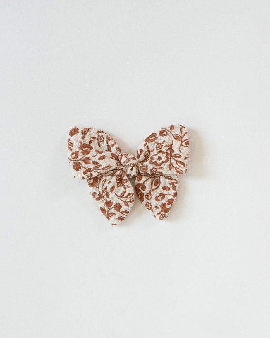 Butterfly-shaped hair clip with a pattern on a light gray background