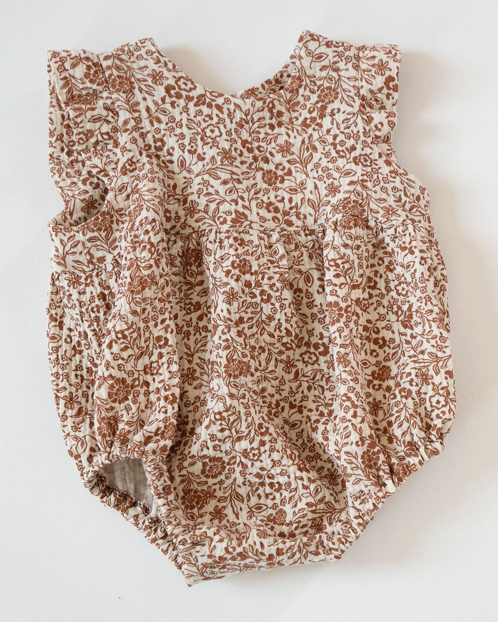 Brown floral-patterned baby romper on a white background