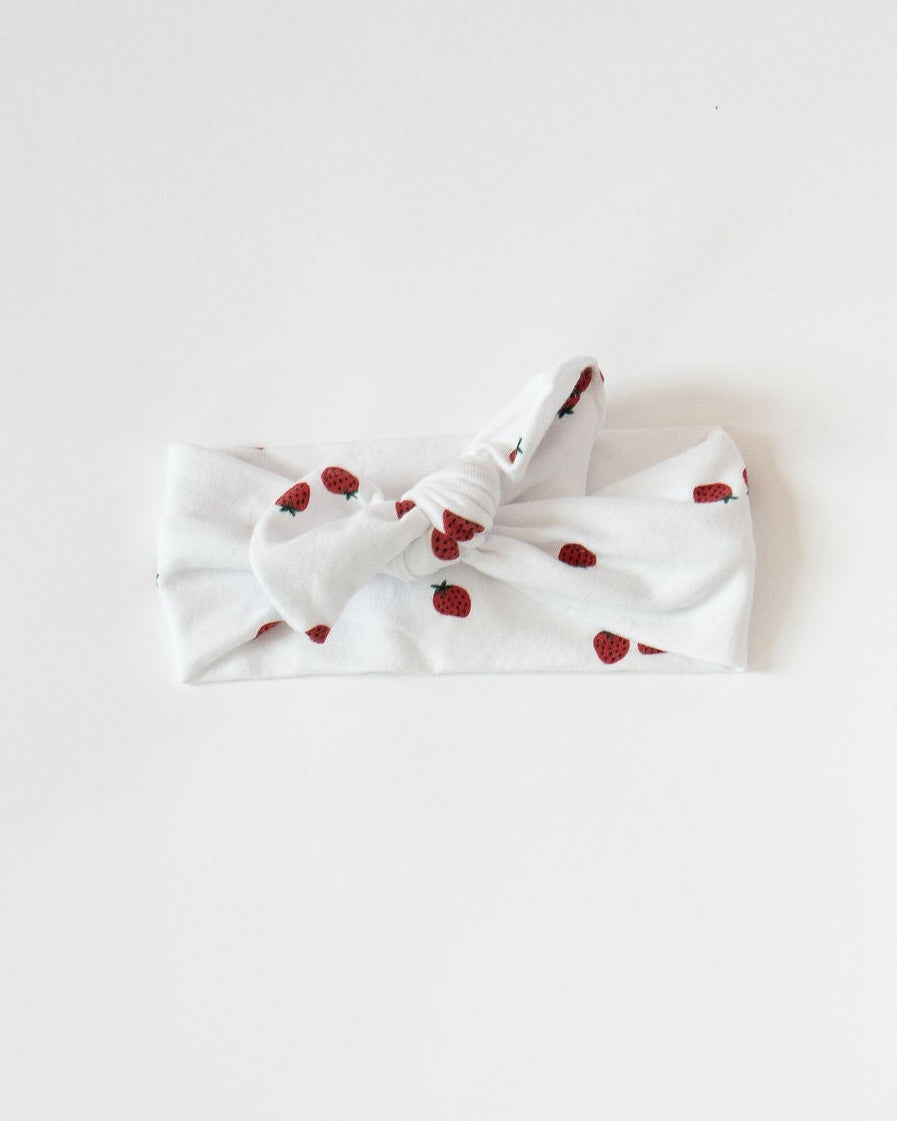 White bow with red polka dots on a light gray background