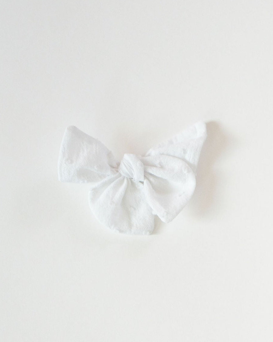 White bow tie on a light gray background