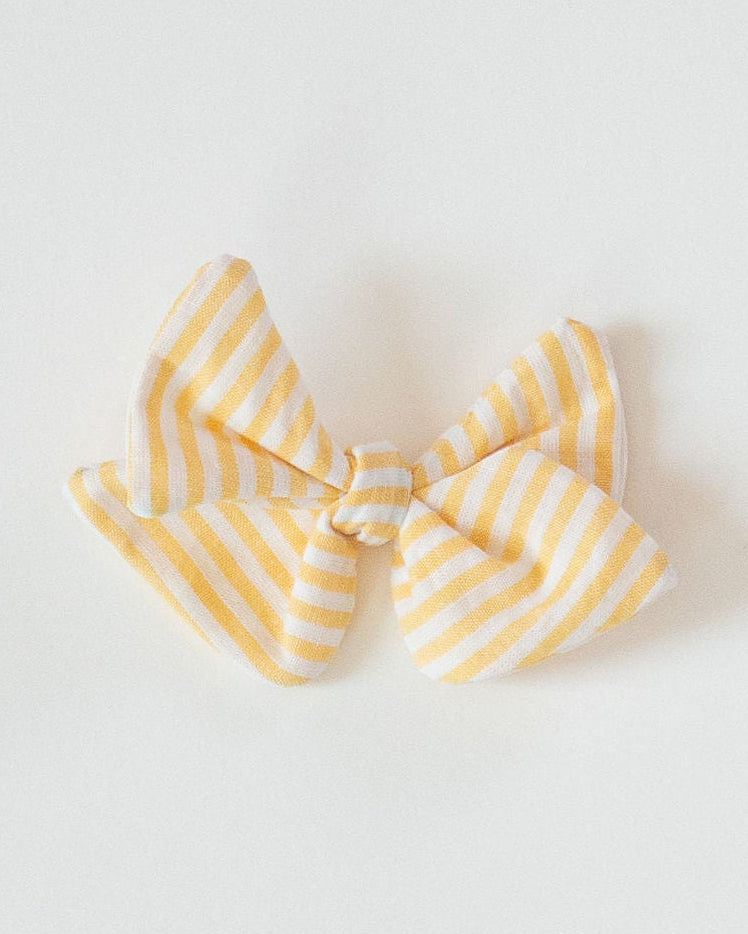 Two bow-shaped pasta pieces on a light gray background