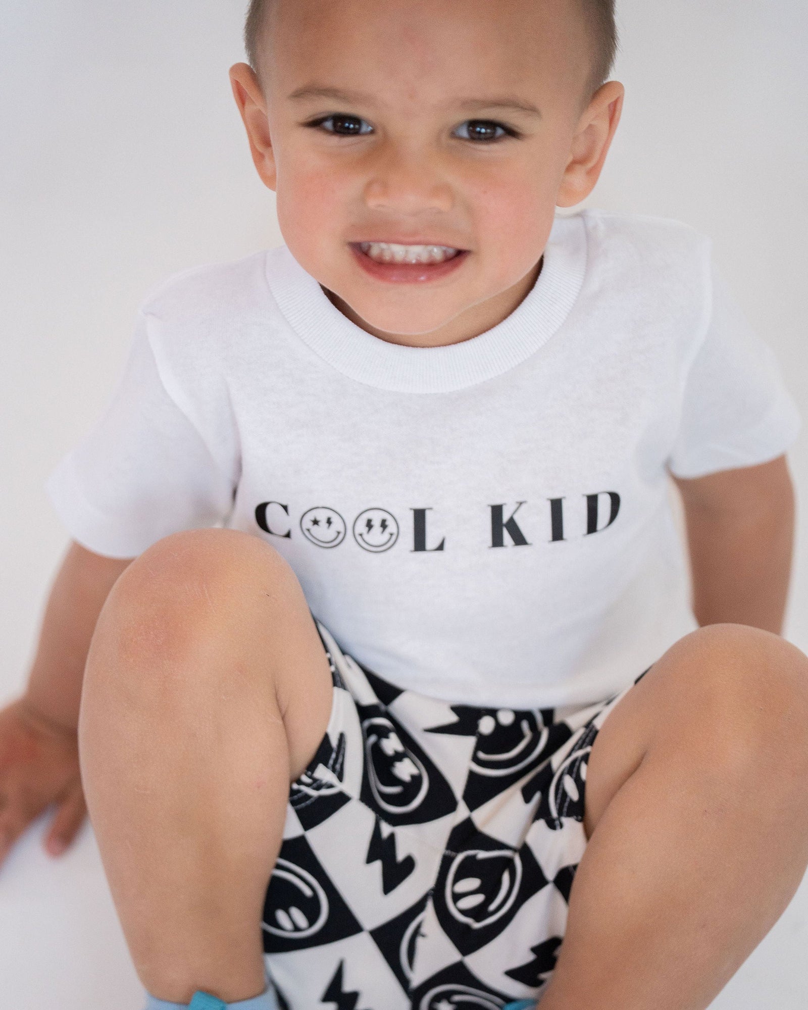 White t-shirt with 'COOL KID' text on a light gray background