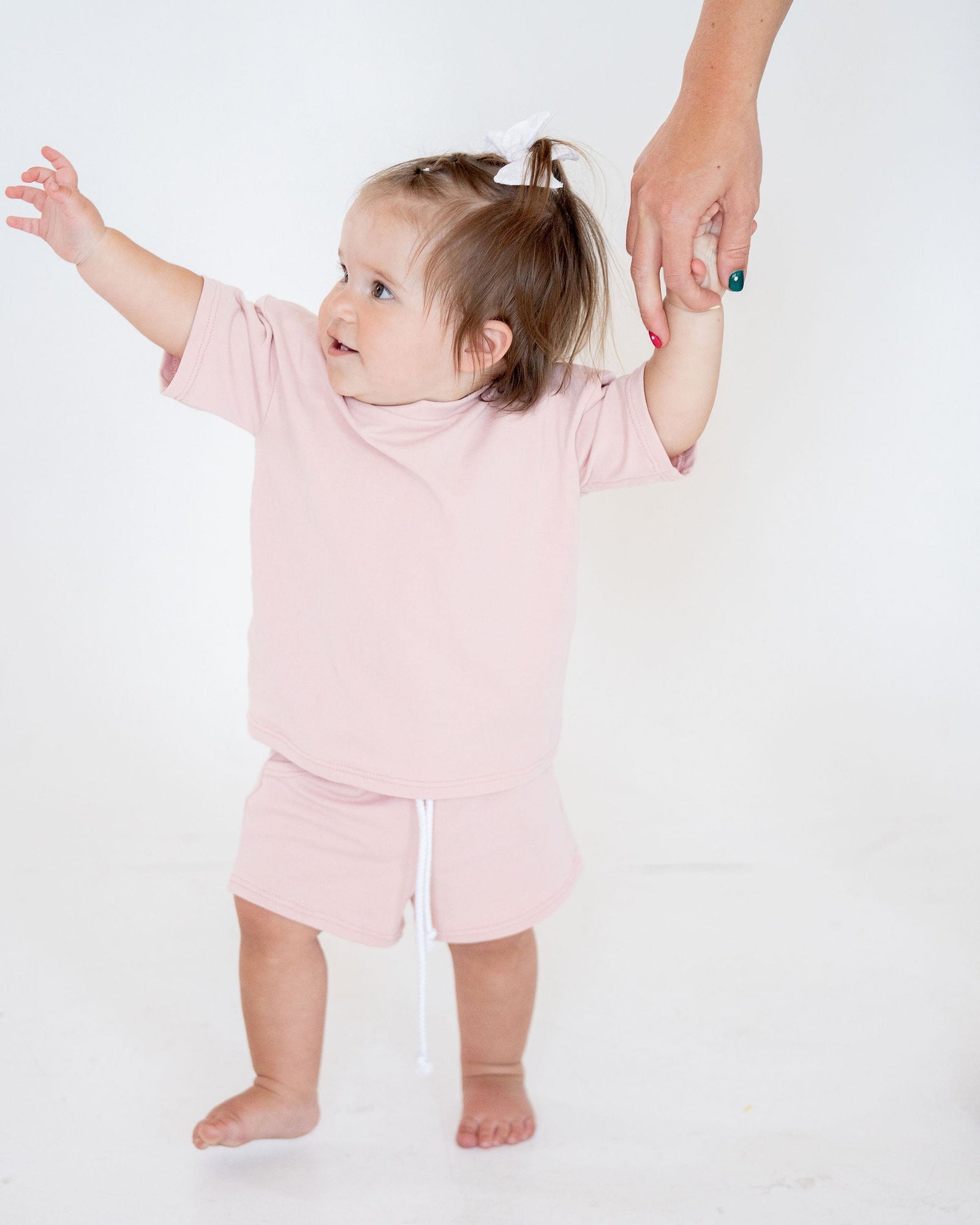 Pink shorts with a white drawstring on a light gray background